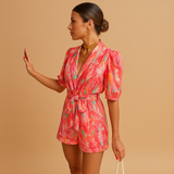 Floral short jumpsuit for women with waist belt and vibrant print, perfect for warm days, summer occasions, and stylish evenings out.