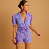 Floral short jumpsuit for women with waist belt and vibrant print, perfect for warm days, summer occasions, and stylish evenings out.