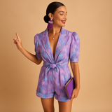 Floral short jumpsuit for women with waist belt and vibrant print, perfect for warm days, summer occasions, and stylish evenings out.