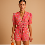 Floral short jumpsuit for women with waist belt and vibrant print, perfect for warm days, summer occasions, and stylish evenings out.